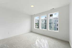 Carpeted empty room featuring baseboards