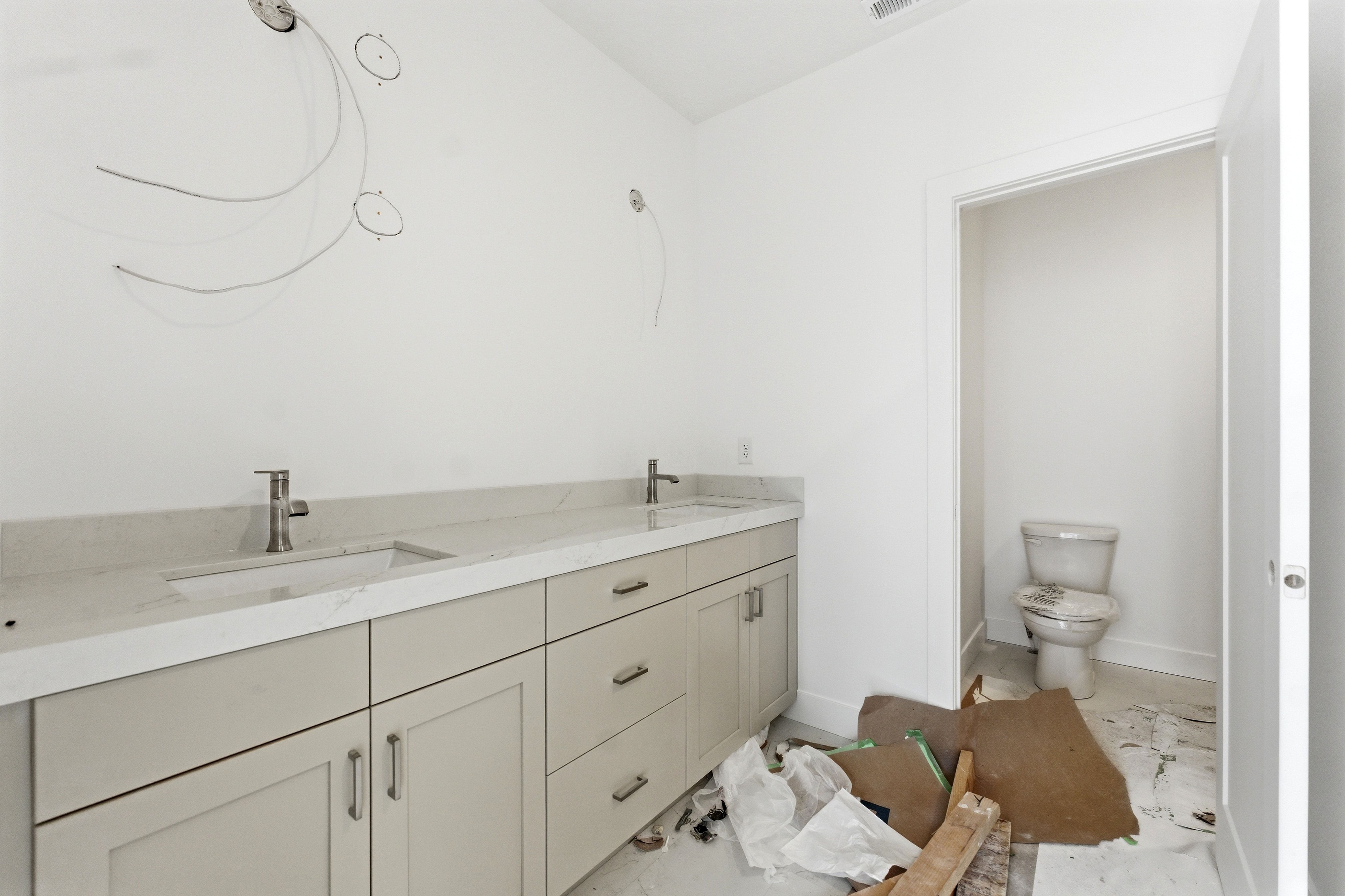Full bath featuring double vanity and toilet