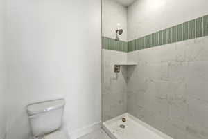 Bathroom with a tile shower and toilet