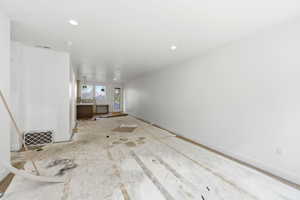 Unfurnished living room with baseboards and recessed lighting