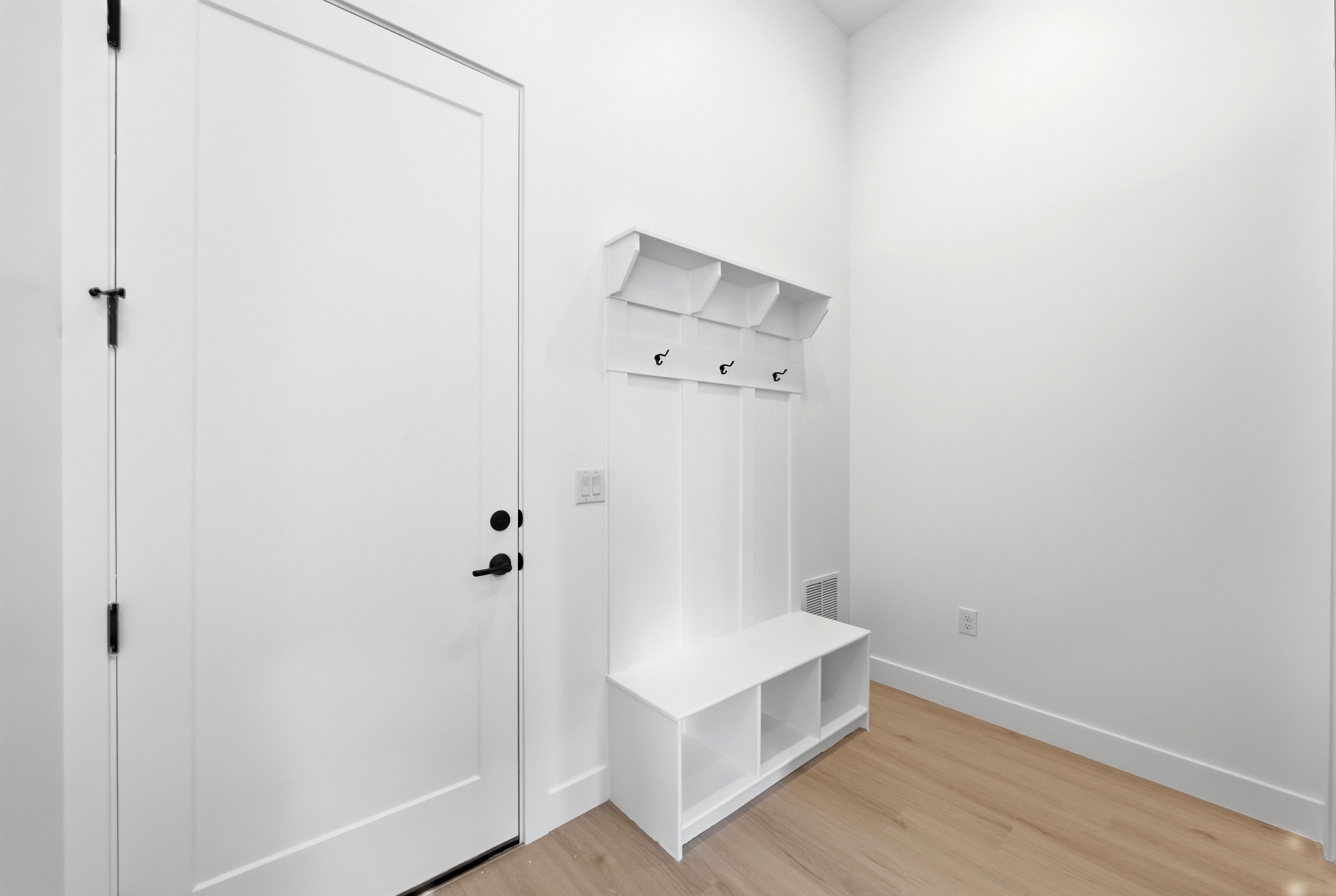 Entryway mudroom with light wood-finish flooring