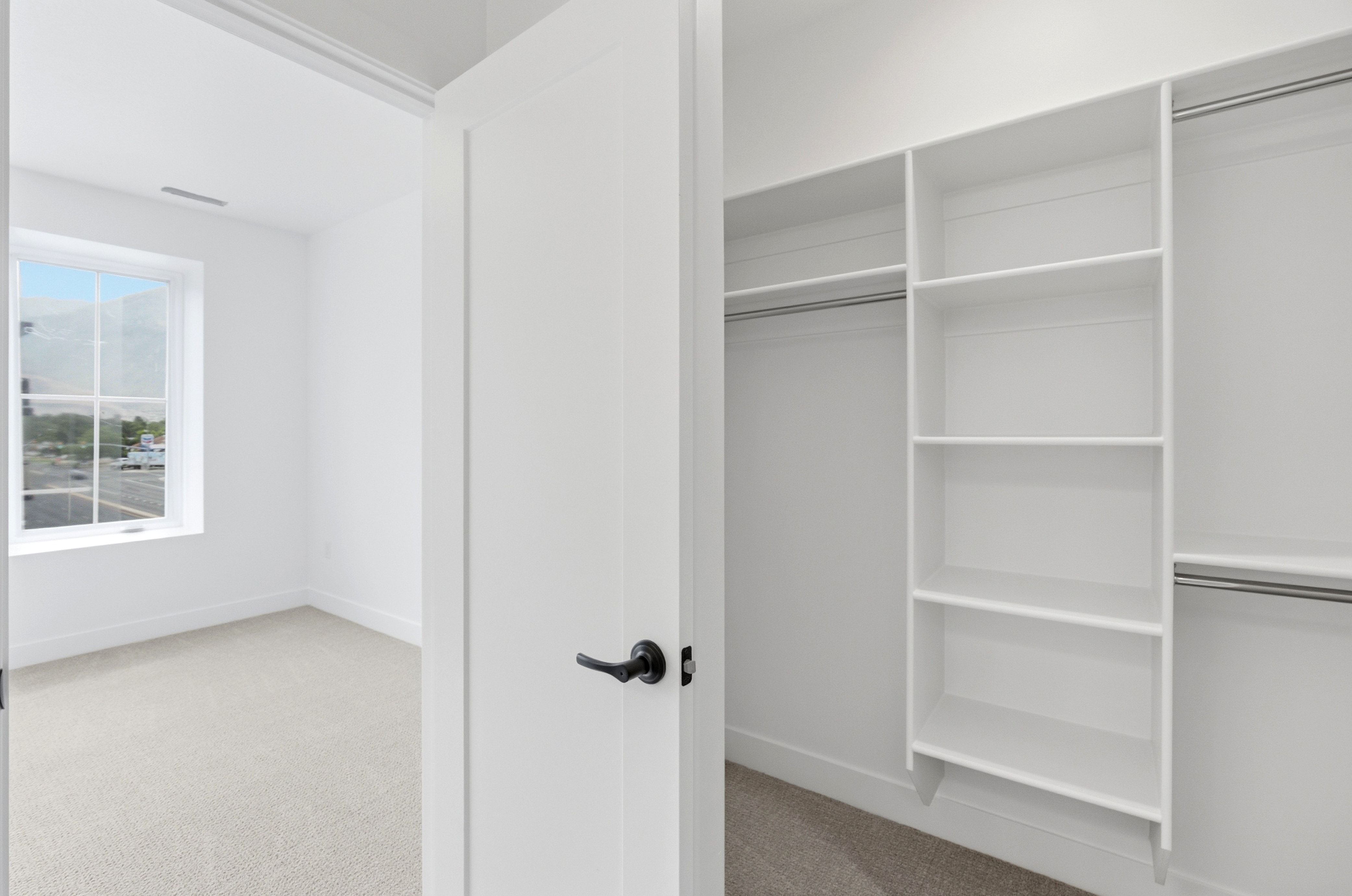 Spacious closet featuring built-in shelving and hanging rods