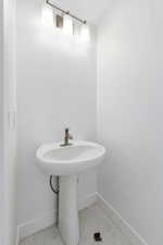 Bathroom with baseboards and light marble finish floors