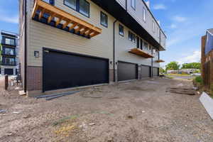 View of property exterior featuring an attached garage and brick siding