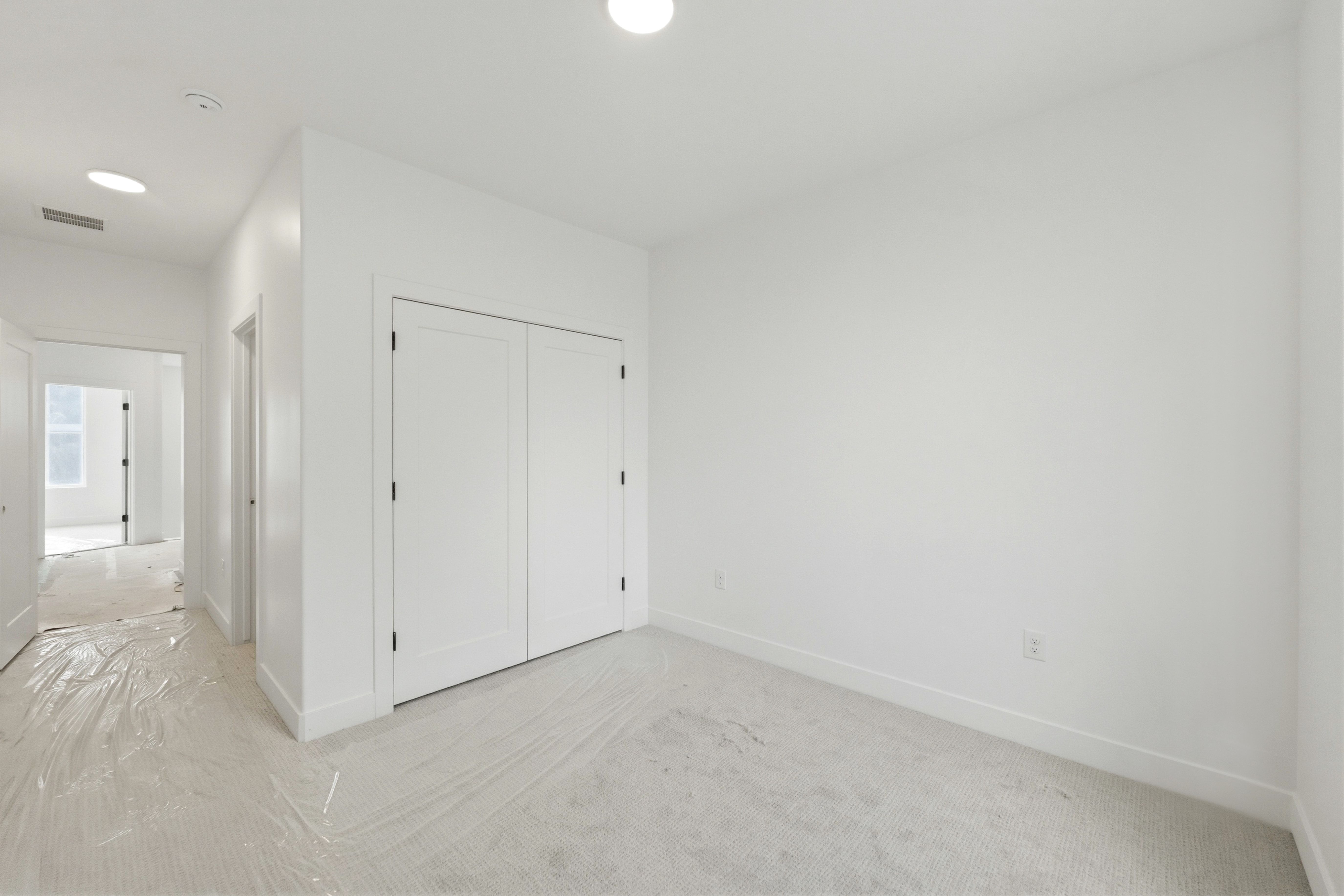 Unfurnished bedroom featuring light colored carpet and a closet