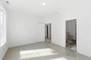 Unfurnished bedroom featuring connected bathroom and light carpet