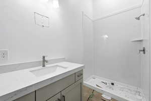Full bathroom with vanity and a shower stall