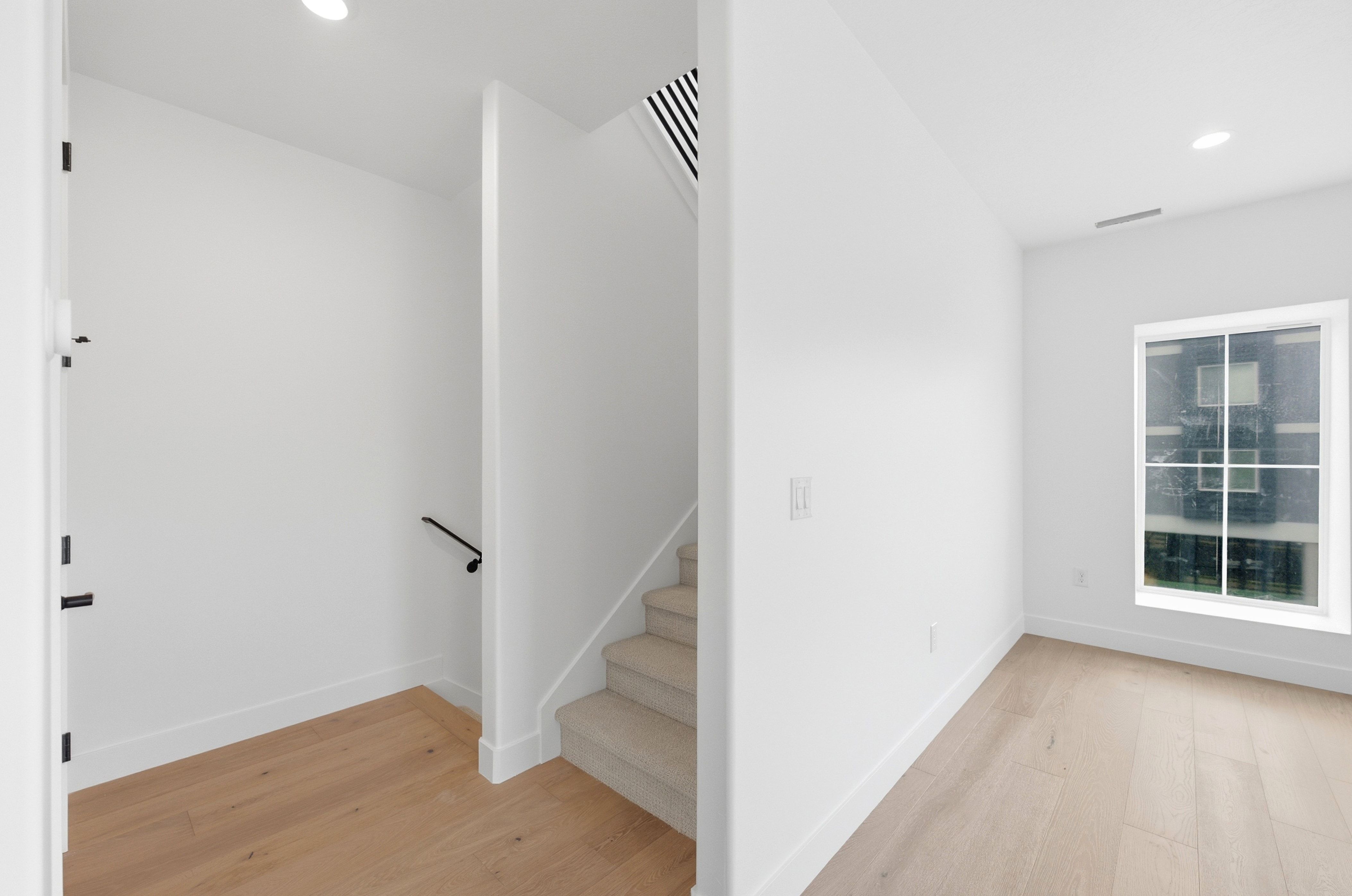Entryway with light wood-finish flooring, white baseboards, and bright white walls
