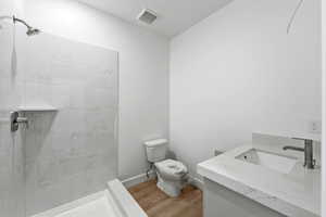 Full bathroom with vanity, a marble finish shower, and light wood finished floors