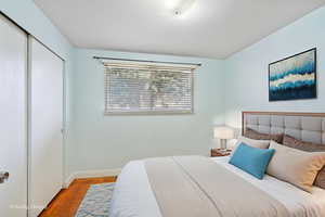 Bedroom featuring wood finished floors and a closet
