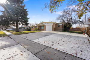 View of front of home featuring brick siding, concrete driveway, and a garage