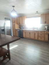 Kitchen with decorative light fixtures, stainless steel appliances, dark wood finished floors, and light stone counters