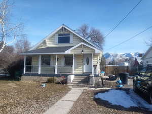 View of front of property featuring a porch, a shingled roof, and a mountain view