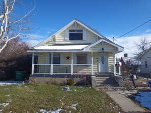 View of front facade featuring a porch and a lawn