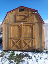 Snow covered structure with a shed