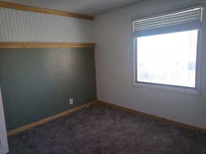 Spare room with carpet floors and wallpapered walls