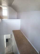 Stairway featuring a textured ceiling and baseboards