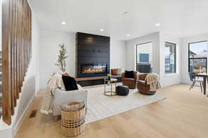 Living area with light wood-type flooring, recessed lighting, and a fireplace