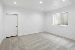 Unfurnished room with light colored carpet and recessed lighting