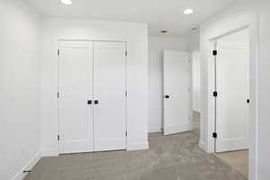 Unfurnished bedroom with light colored carpet, recessed lighting, and a closet