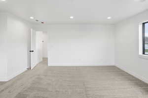 Empty room featuring recessed lighting and light colored carpet
