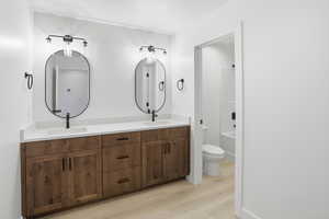 Bathroom featuring double vanity, light wood-type flooring, and bathtub / shower combination
