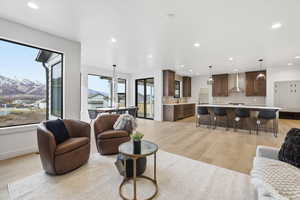 Living area with a mountain view, light wood-style floors, recessed lighting, and a ceiling fan