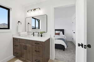 Ensuite bathroom featuring vanity and baseboards