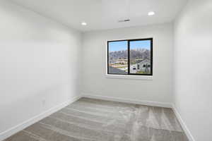 Spare room with light colored carpet, recessed lighting, and a mountain view