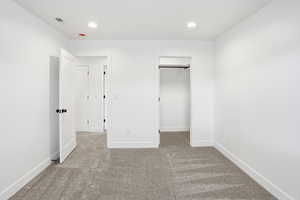 Unfurnished bedroom featuring light colored carpet, recessed lighting, and a spacious closet