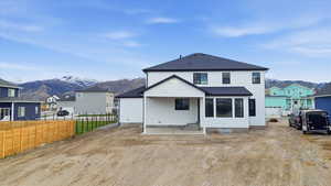 Rear view of house with a patio area, a shingled roof, a mountain view, and a residential view