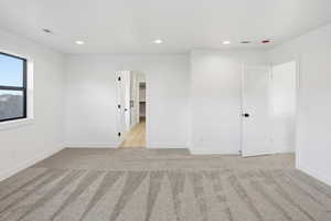 Spare room featuring recessed lighting and light carpet