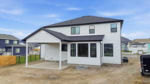 Back of property with roof with shingles and a patio area