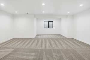 Empty room with recessed lighting and light carpet