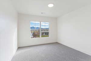 Carpeted spare room featuring baseboards and a mountain view