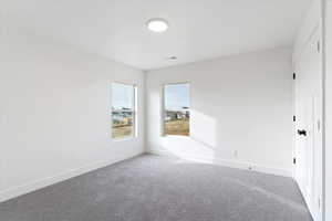 Empty room featuring baseboards and carpet floors