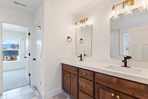 Full bathroom with plenty of natural light, double vanity, and light carpet