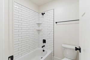 Full bathroom with washtub / shower combination and toilet