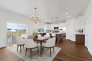 Dining space featuring a chandelier, dark wood finished floors, and recessed lighting