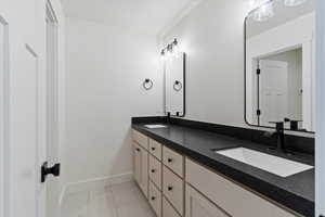 Full bathroom featuring double vanity and light tile patterned floors