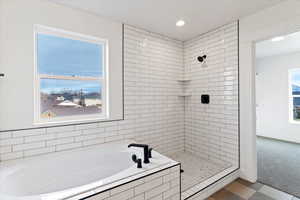 Full bath with a bath, a shower stall, and recessed lighting