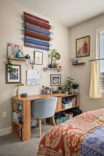 Bedroom with an office area and carpet flooring