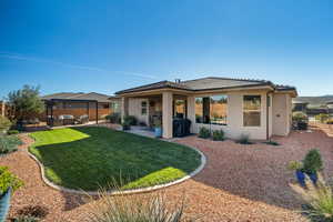 Back of property featuring a patio, stucco siding, and a tile roof