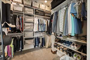 Walk in closet featuring light colored carpet