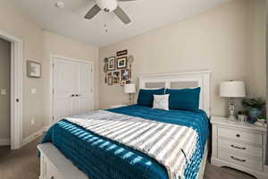 Carpeted bedroom with a closet and ceiling fan