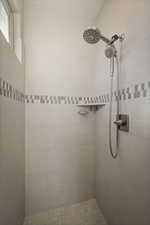 Full bath featuring tiled shower