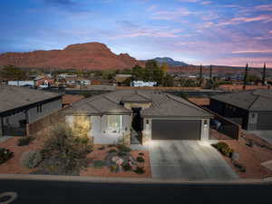 Ranch-style house featuring a residential view, a gate, an attached garage, driveway, and stucco siding