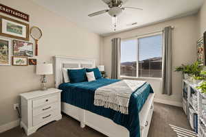 Bedroom with a ceiling fan and dark carpet