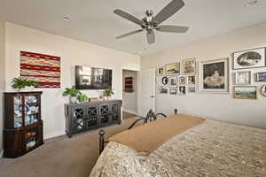 Carpeted bedroom featuring baseboards and a ceiling fan