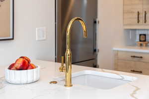 Kitchen view of light brown cabinetry and light stone counters